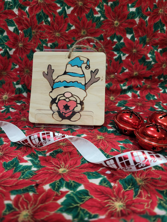 blue and white striped hat gnome with reindeer horns and holding a present